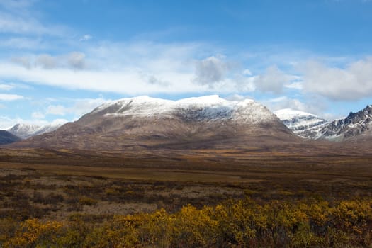 Wilderness of Alaska tundra in late fall with snow on mountains