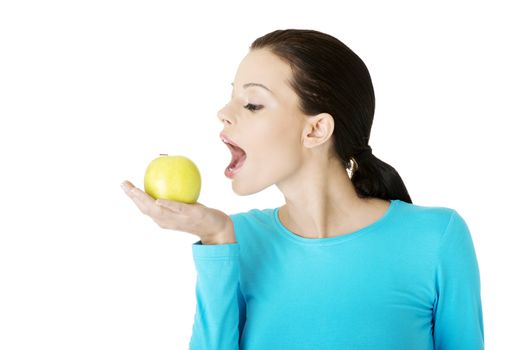 Attractive young woman eating green apple. Isolated on white background