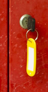 A red metal locker with tagged key attached.