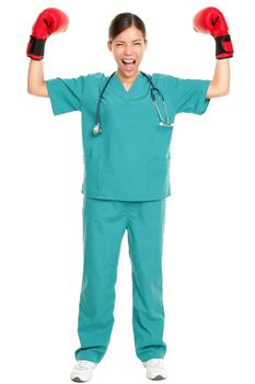 Medical nurse / doctor boxing challenge concept image. Young nurse in scrubs and boxing gloves showing strength and muscles standing in full length isolated on white background.