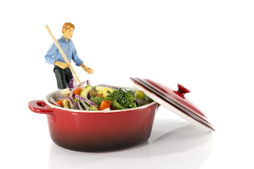 plastic model man stir vegetarian food in red saucepan