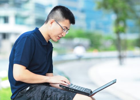 Young man using laptop outdoor