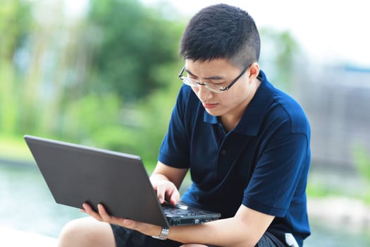 Young man using laptop outdoor