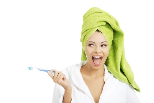 Happy attractive woman pointing on copy space with tooth brush, isolated on white