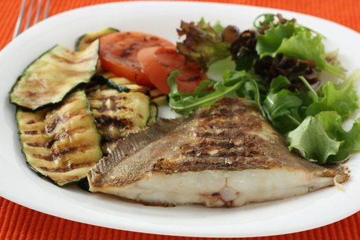 fried fish with vegetables and salad