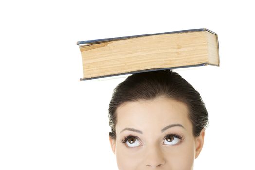 Attractive young student woman with book on head, isolated on white background