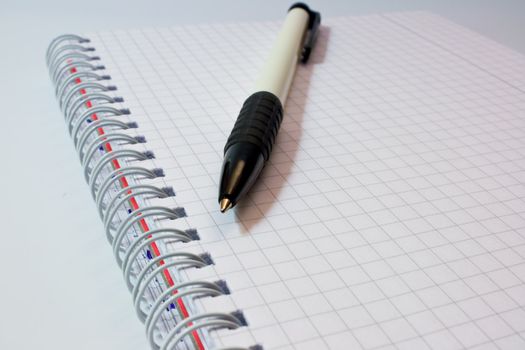 The handle lies on an open notebook and is photographed on a grey background