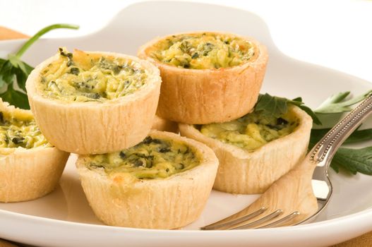 Delicious and homemade small quiche on a plate.