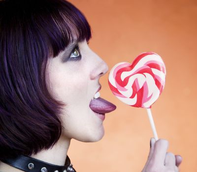 Close-up of an Alternative Girl with a Heart Lollipop