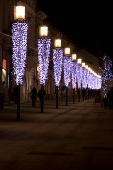 People walking along a row of lights