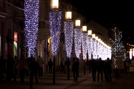 People walking along a row of lights