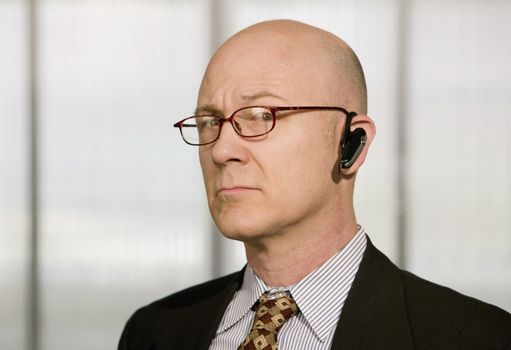 Portrait of businessman with a hands-free phone in his ear