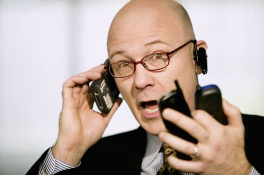 Portrait of businessman with several cell phones