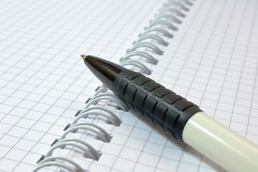 The handle lies on an open notebook and is photographed on a grey background