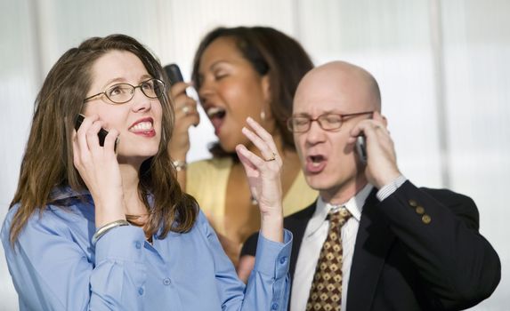 Selective focus on three businesspeople using cell phones