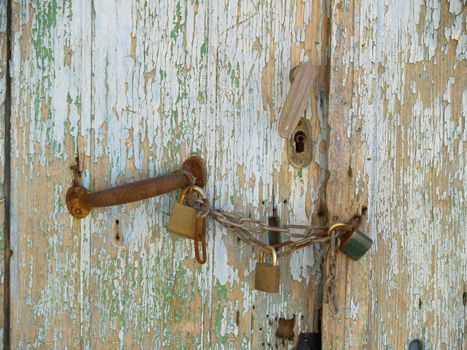 old wooden door locked with chain and three locks