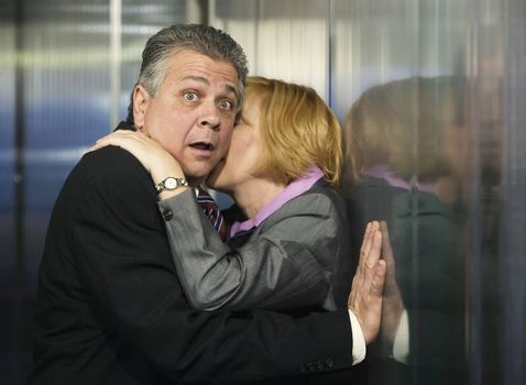 Couple caught in an embrace in a corporate office
