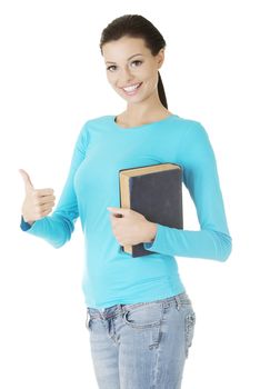 Attractive young student woman with book gesturing OK, isolated on white