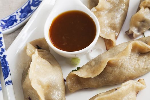 Potstickers appetizer with orange soy sauce.