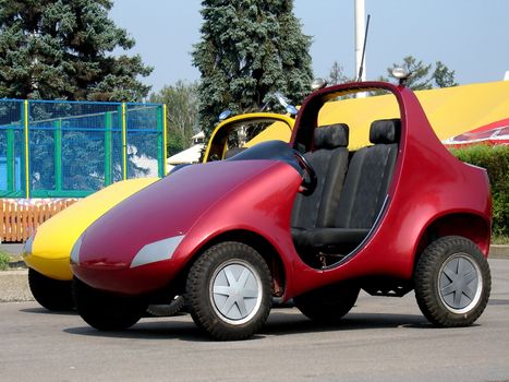Pair of red and yellow child electro cars