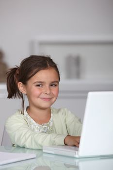 Little girl sat with laptop computer