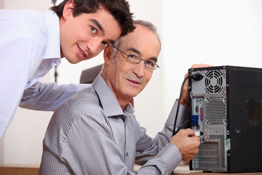 Father and son fixing a computer