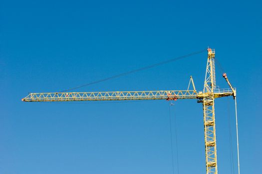 Arrow of the tower crane on a background of the blue sky