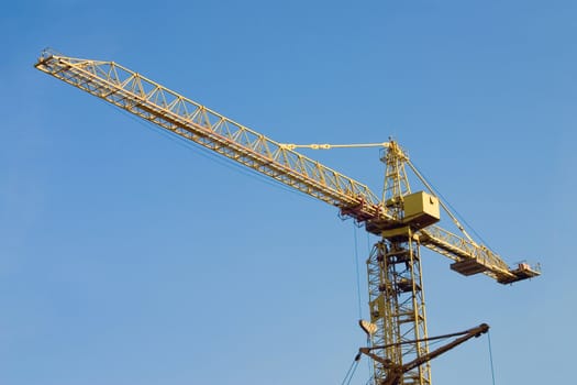Arrow of the tower crane on a background of the blue sky
