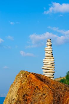 Stack of pebbles in the balance on the sea boulder