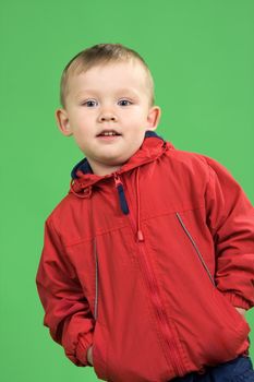 The boy in a red jacket on a green background