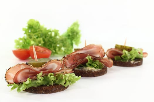 Canapes with smoked bacon and sour cucumber