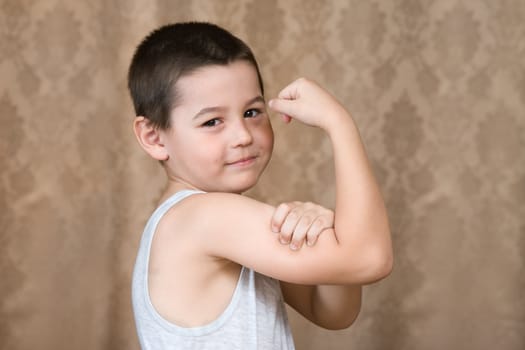 The boy shows muscles of hands