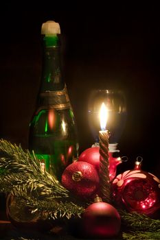 Candle and christmas-tree decorations on a black background