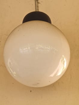 A photo of round white lamp on white wall