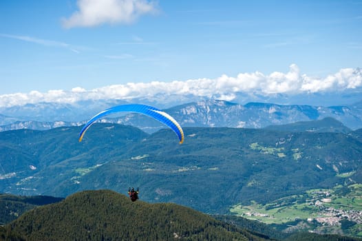 Paraglider flying over the Alps of Trentino