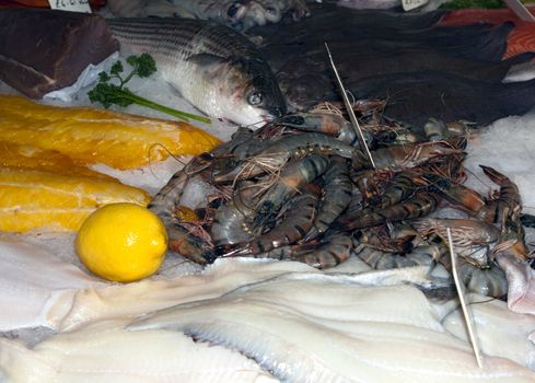 A variety of freshly caught fish and prawns on ice in a fish shop in Hastings, England
