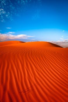 Red outback ripple sand dune desert with blue sky.