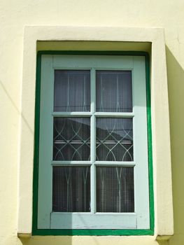 Light blue french panel window on lemon yellow wall