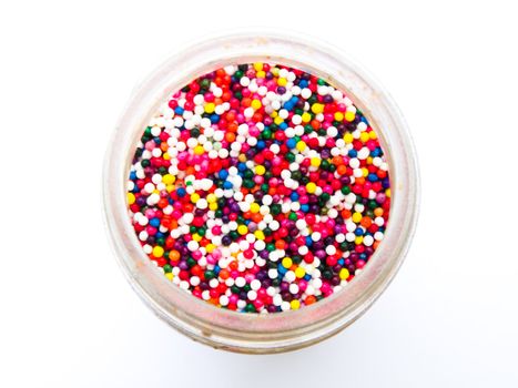 Sugar sprinkle dots in a bottle isolated in white background from topview