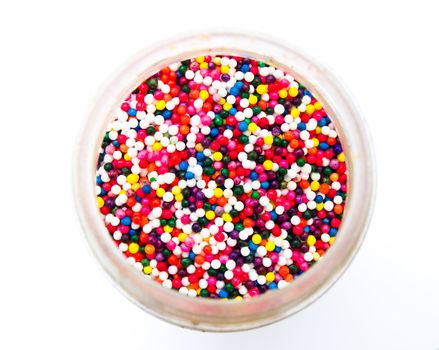 Sugar sprinkle dots in a bottle isolated in white background from topview