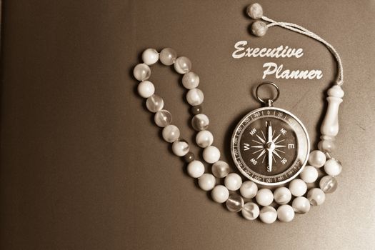 executive planner with rosary beads in sepia tone