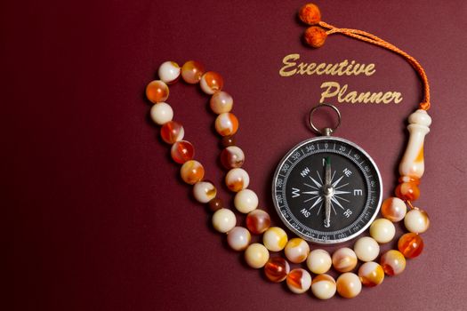 dark red executive planner with rosary beads in landscape orientation