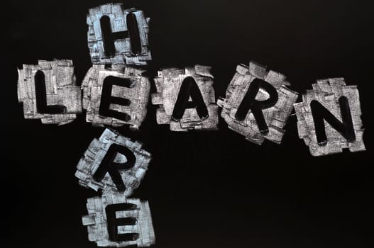 Crossword of Learn Here written in chalk on a blackboard