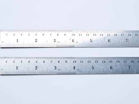 A pair of used stainless steel rulers isolated on white background