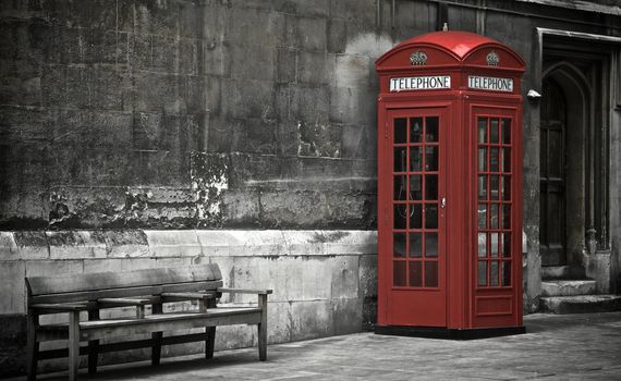 British phone booth with weathered wooden bench