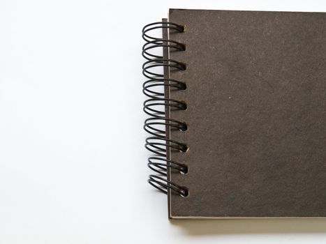A black spiral binding notebook on white