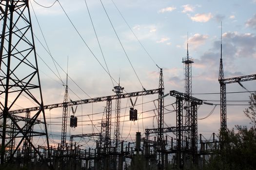 Electric substation on a background of the coming sun