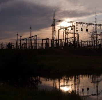 Electric substation on a background of the coming sun