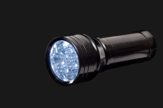 Small black flashlight  on a black background