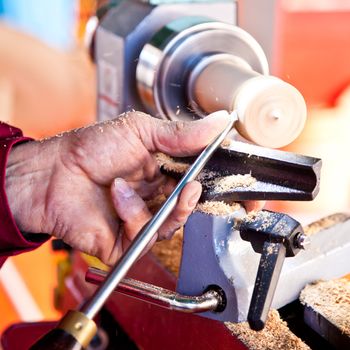 Old worker hands at lathe